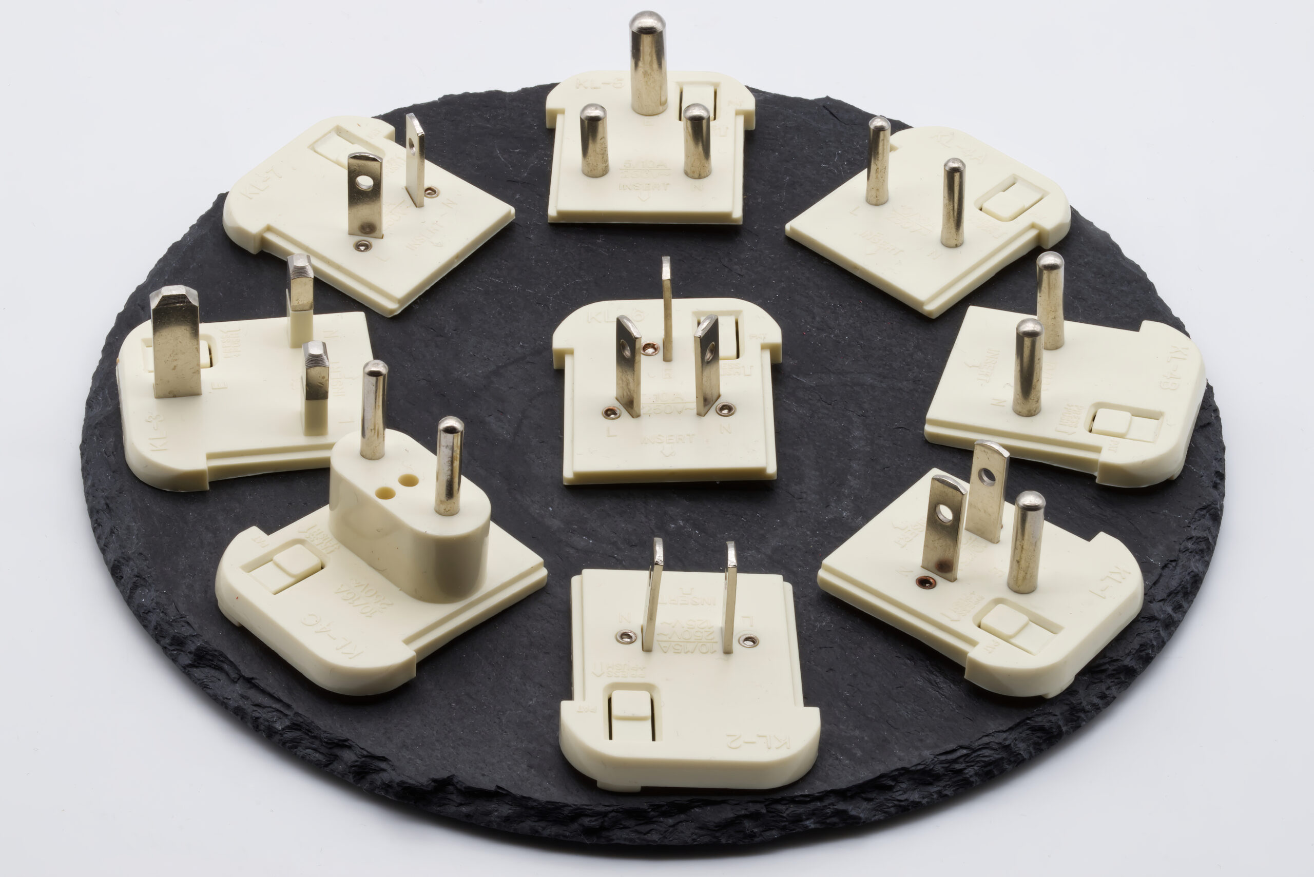 diversos adaptadores de tomada internacional para viagem sobre um mapa mundi